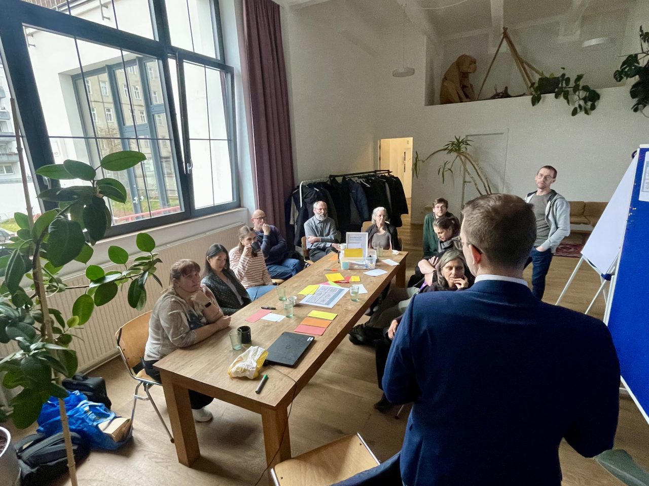 Gruppe von Menschen sitzt an einem Tisch bei einem Workshop