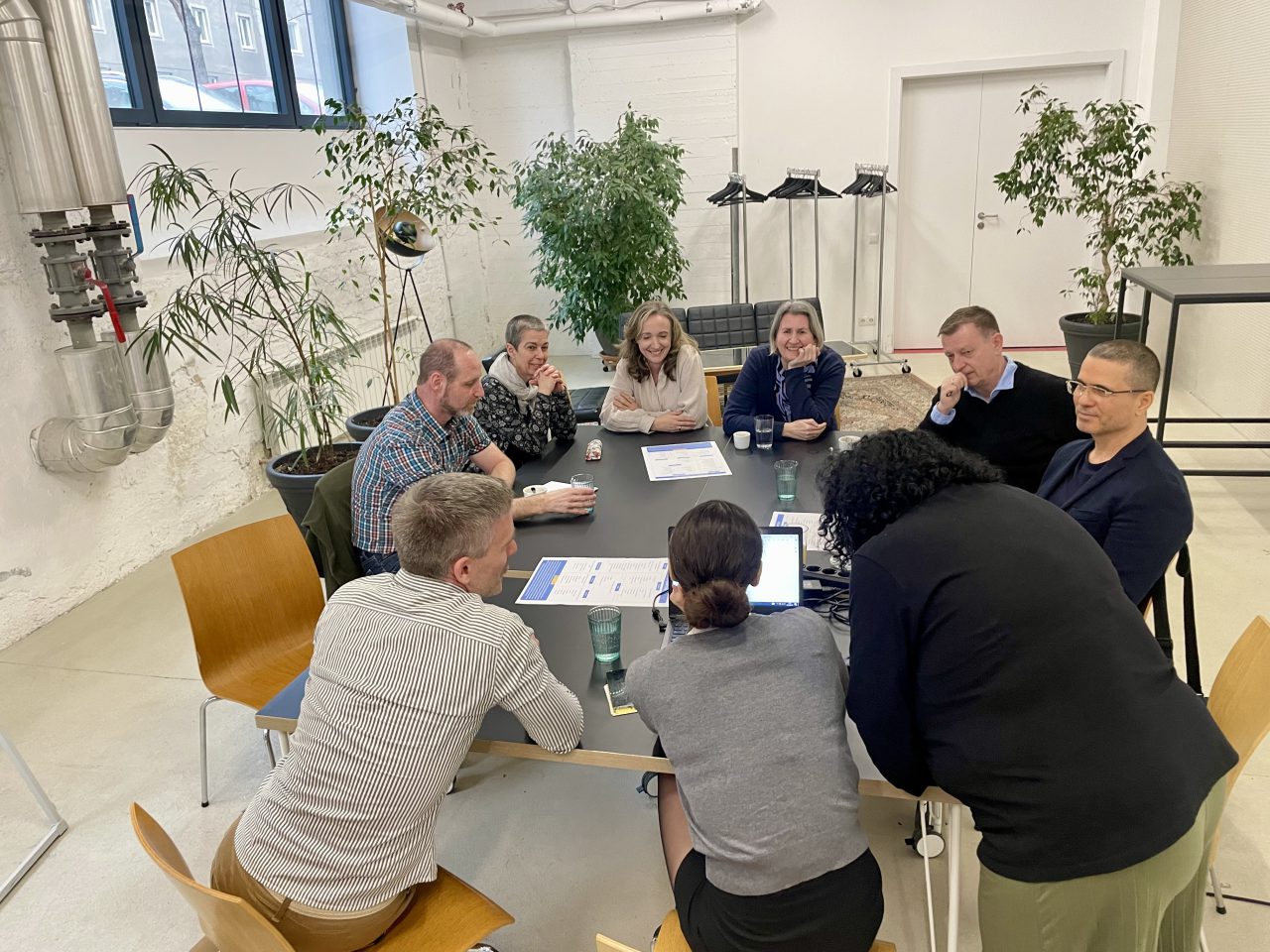 Gruppe von Menschen sitzt an einem Tisch bei einem Workshop